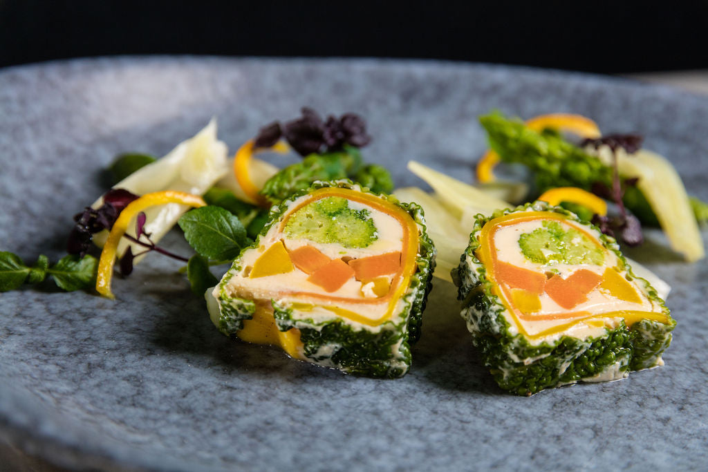 Gemüse-Terrine von Degusta Manufaktur mit Wirsingmantel, Rüebli und Peperoni auf grauem Teller