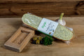 Knoblauch-Brot mit Oliven von Degusta Manufaktur in der Verpackung, dazu Knoblauch, Oliven und Petersilie