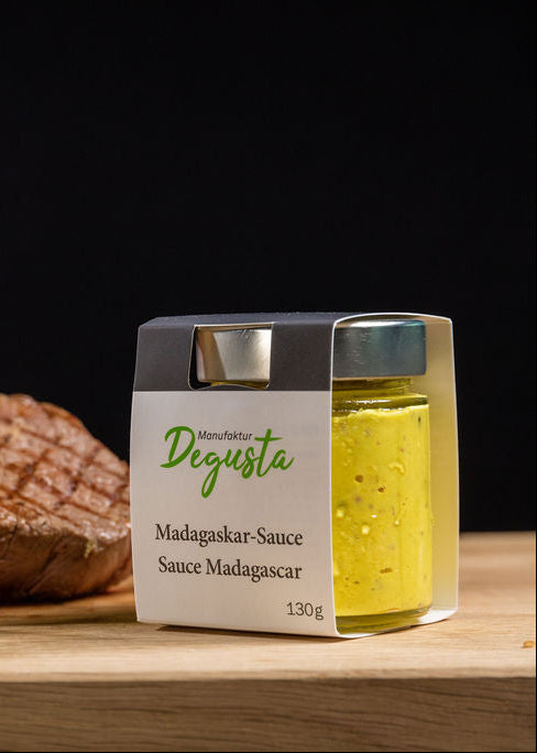 Madagaskar-Sauce von Degusta Manufaktur in Verpackung und Glas, dazu grilliertes Rindssteak