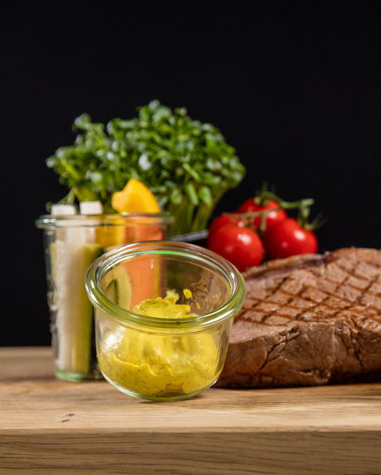 Madagaskar-Sauce von Degusta Manufaktur in Verpackung und Glas, dazu grilliertes Rindssteak