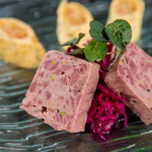 Wild-Terrine von Degusta Manufaktur, angerichtet mit Rotkraut und Kresse auf Glasteller