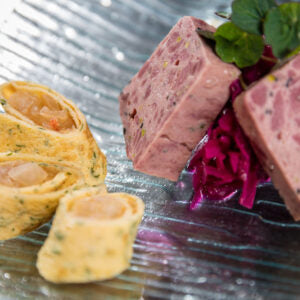 Wild-Terrine von Degusta Manufaktur – Nahaufnahme mit Rotkraut und gefüllten Crêpe-Röllchen